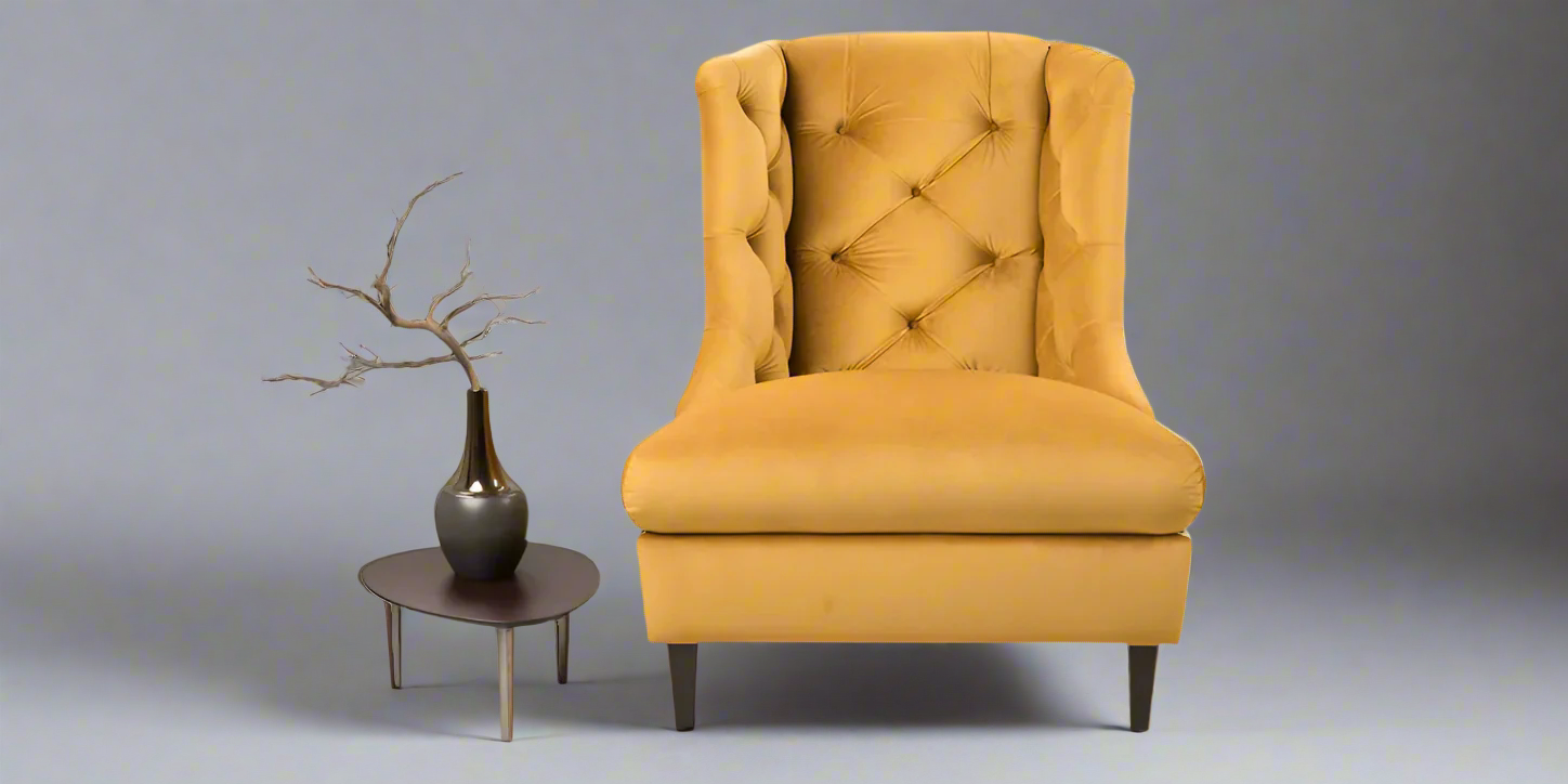 A yellow upholstered Lugo armchair with decorative puffs, featuring sheet wood legs, alongside a small round side table with a decorative item on top.